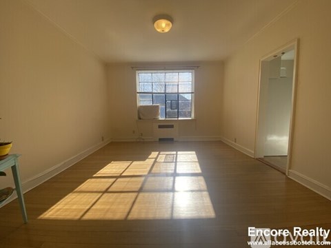 A sunny room with a window and a table with a bowl on it.
