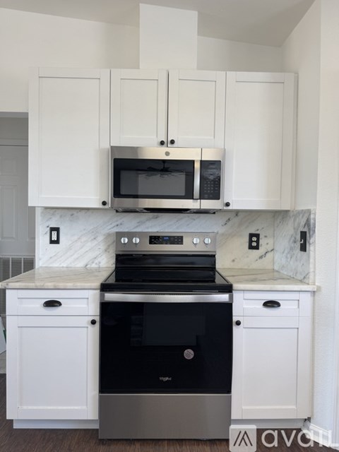 A kitchen with white cabinets and a black oven.