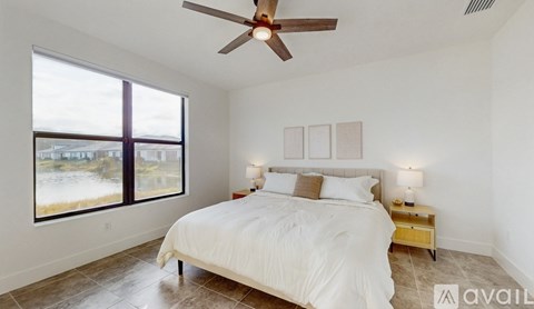 A bedroom with a large bed and a ceiling fan.
