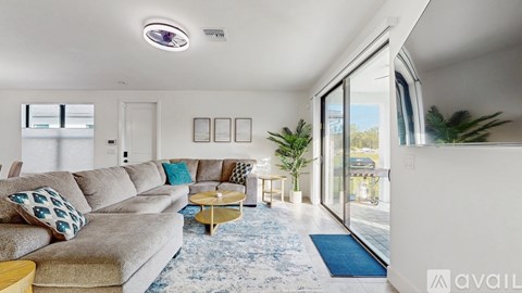 A living room with a grey couch and a blue rug.