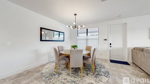 A dining room with a round table and chairs.