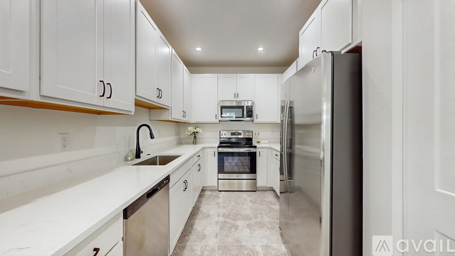 A kitchen with white cabinets and appliances.