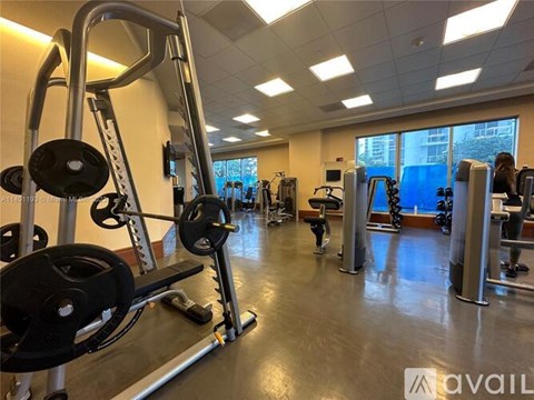 A gym with a variety of equipment including a weight bench and a treadmill.