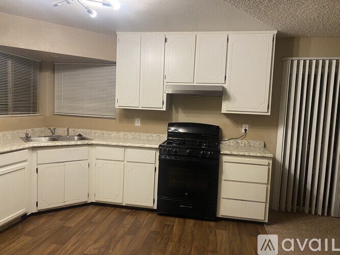 A kitchen with white cabinets and a black dishwasher.