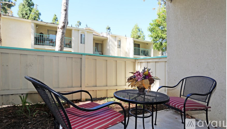 A patio with a table and chairs with a view of a building.