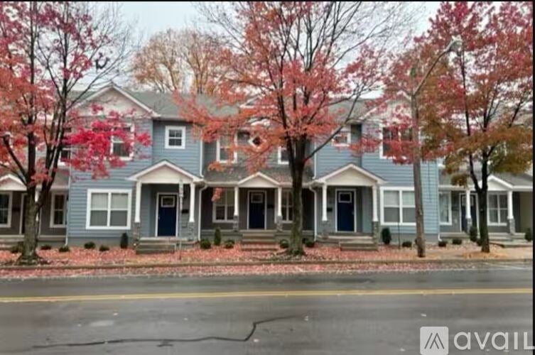 A row of houses with trees in front of them.