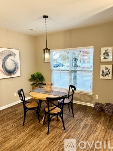 A dining room with a round table and chairs.