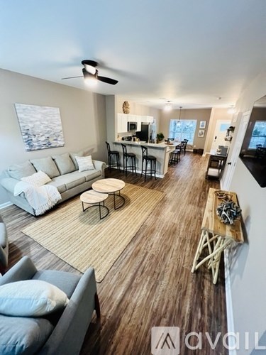 A living room with a white couch and a wooden floor.