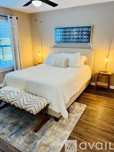 A bedroom with a large bed and a wooden bench.