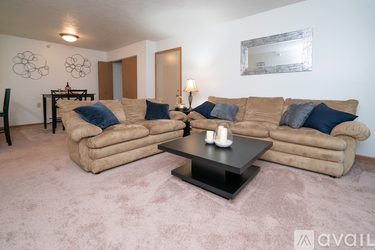 A living room with a tan couch and a black coffee table.
