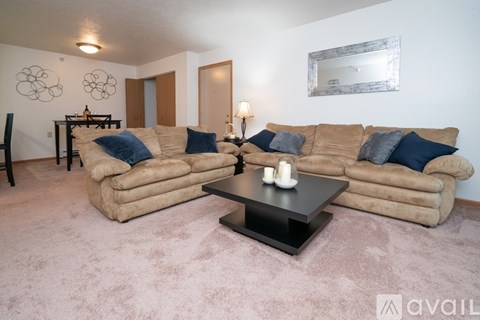 A living room with a tan couch and a black coffee table.