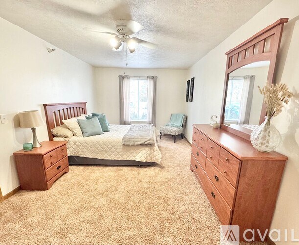 A living room with a sofa set, a coffee table, a television, and a window with blinds.