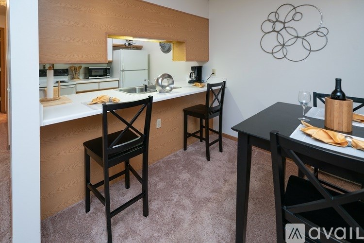 A kitchen with a table and chairs and a sink.