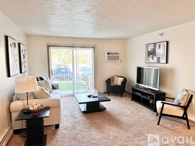 A bedroom with a bed, nightstand, and carpet.