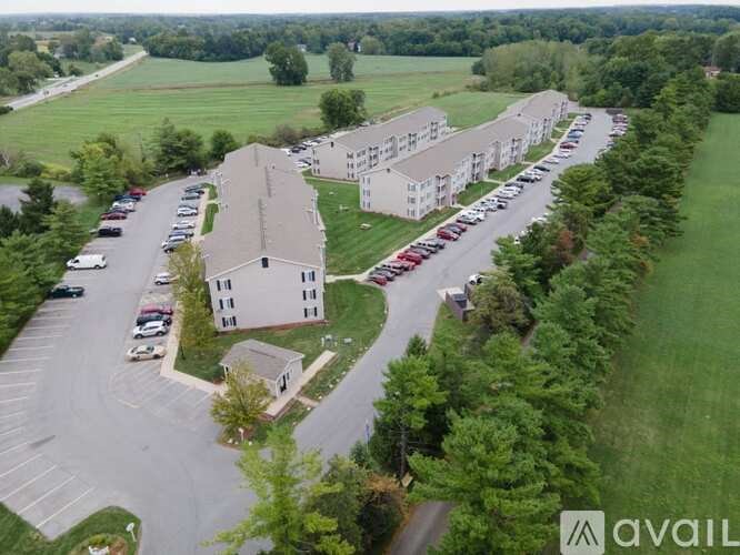 A parking lot with cars and a building in the background.