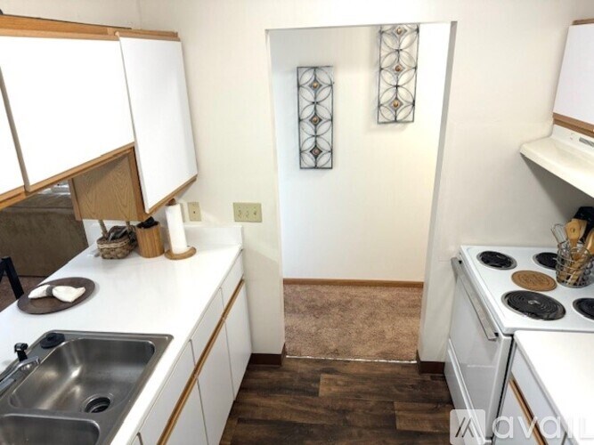 A kitchen with white cabinets and a white stove top oven.