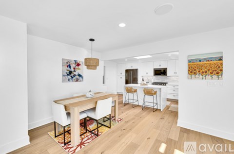 A dining room with a white table and chairs is shown.