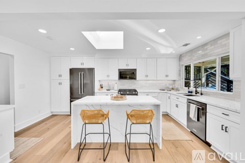 A modern kitchen with white cabinets and a center island.