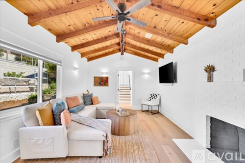 A living room with a white couch and a wooden ceiling fan.