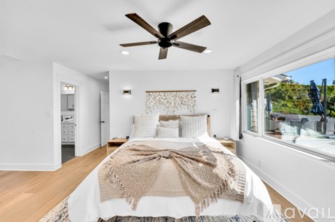 A bedroom with a large bed and a ceiling fan.