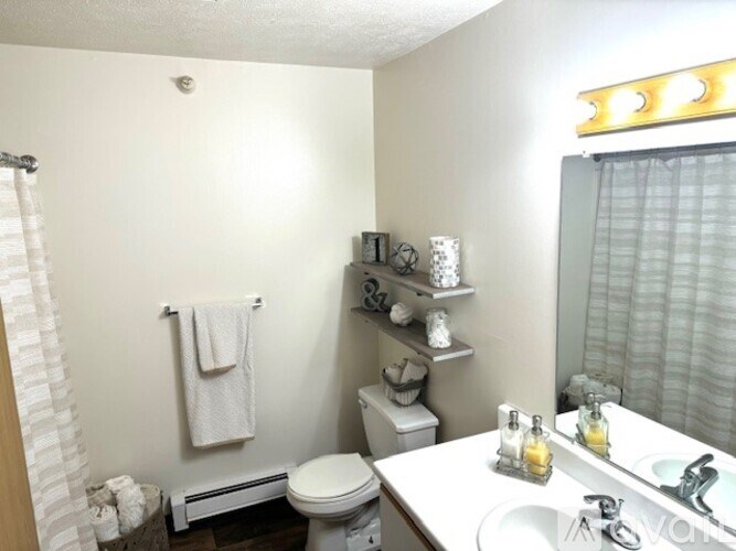 A white toilet sits under a towel rack in a bathroom.
