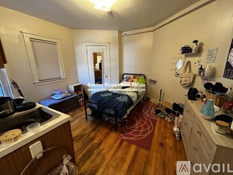 A bedroom with a bed, dresser, and window.