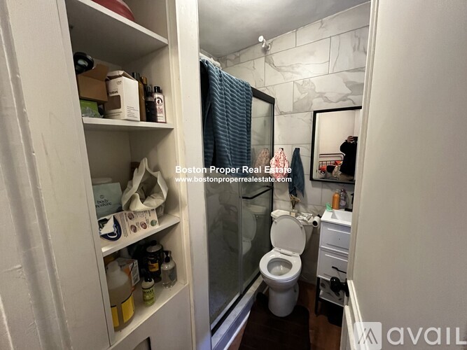 A small bathroom with a toilet, sink, and a cabinet with items on it.