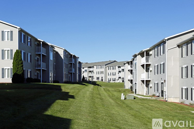 A row of modern apartment buildings with green lawns in front.