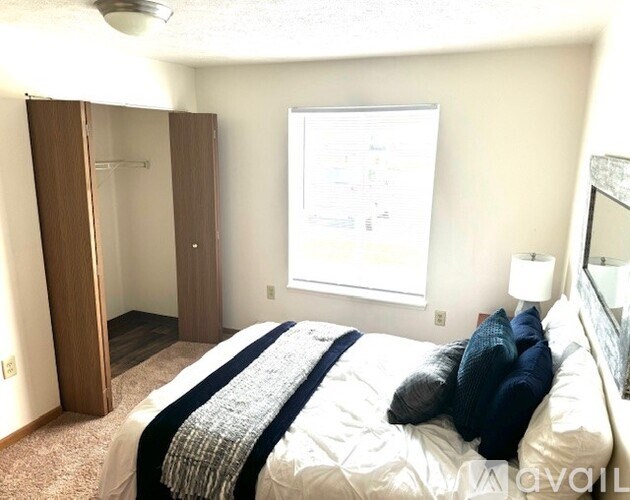 A bedroom with a bed, a dresser, and a mirror.