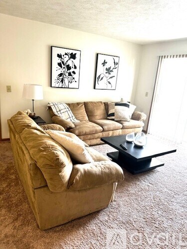 A living room with a beige couch and a coffee table.