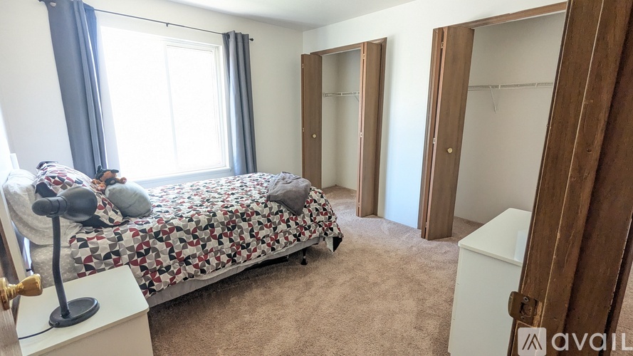 A bedroom with a bed, a dresser, and a wardrobe.