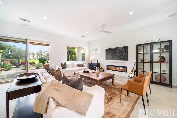 A modern living room with a fireplace and a glass door cabinet.