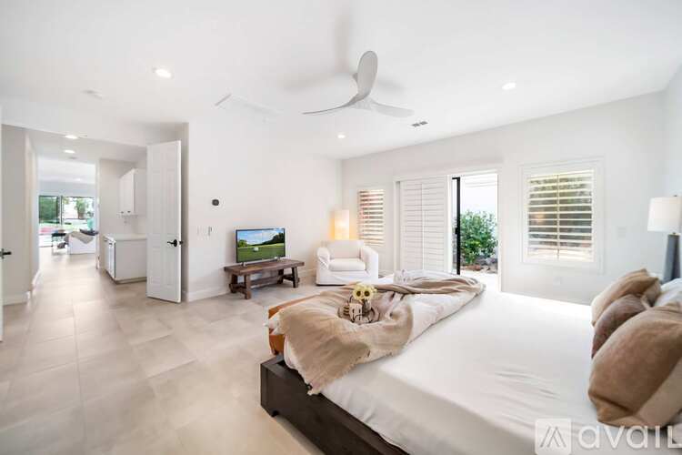 A bedroom with a large bed and a television in the corner.