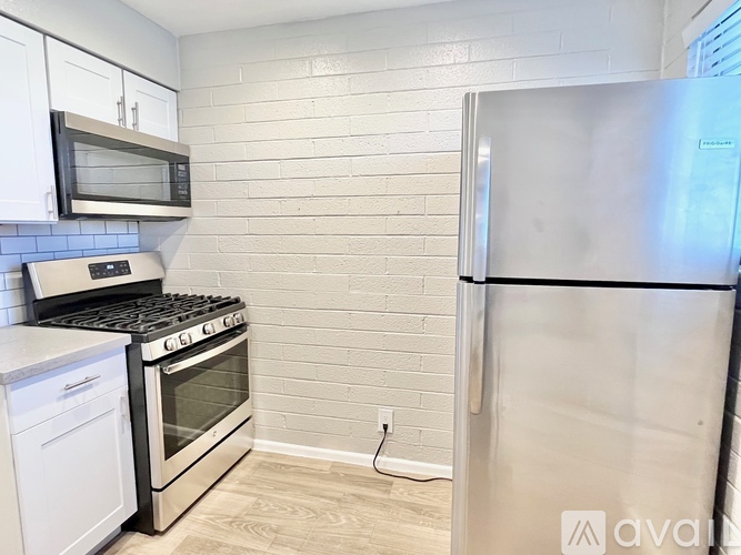 A kitchen with a stove, oven, microwave, and refrigerator.