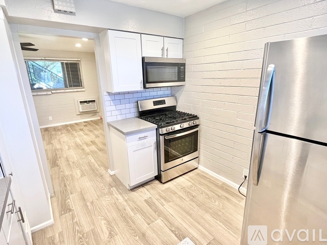 A kitchen with a stainless steel refrigerator, a microwave, a stove, and a dishwasher.