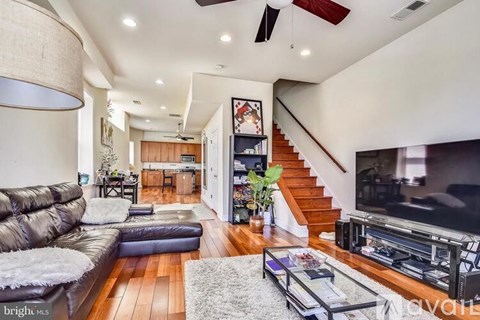 A living room with a brown leather couch and a flat screen TV.