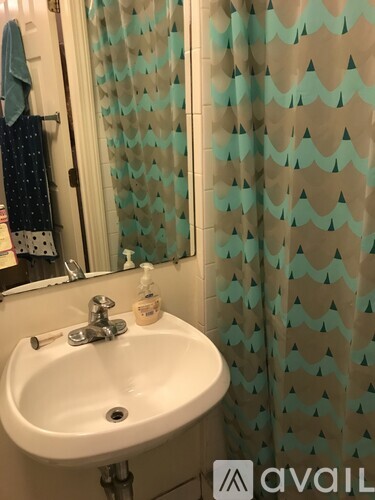 A white sink with a blue towel hanging on the wall.