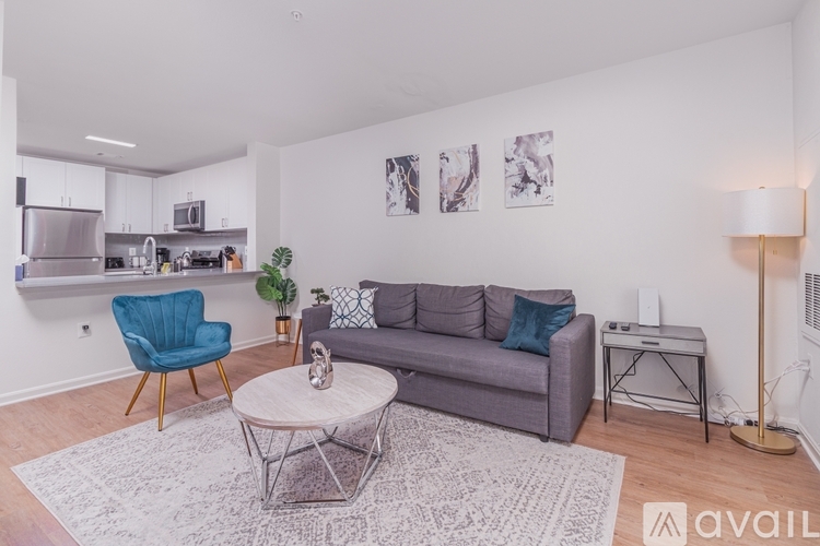 A living room with a grey couch, a blue chair, and a coffee table.