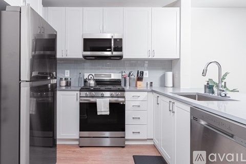A modern kitchen with a stainless steel refrigerator and oven.