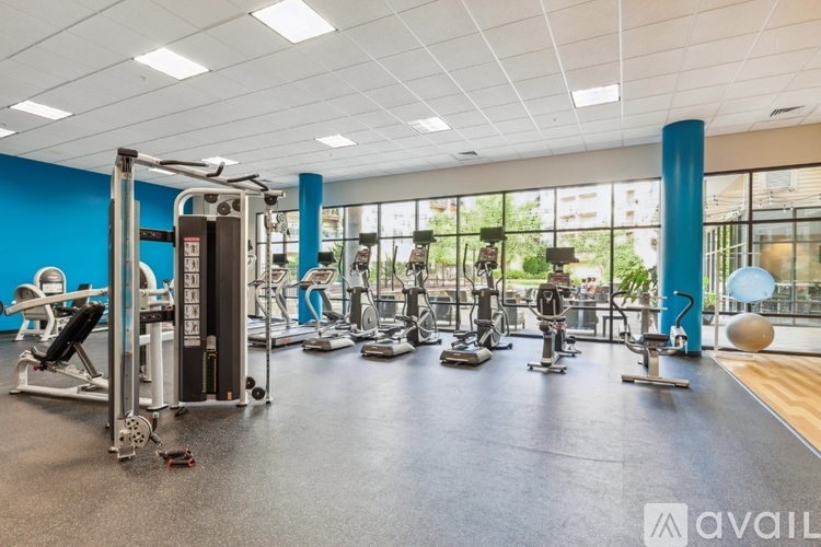 A gym with a variety of equipment including treadmills, weights, and exercise machines.