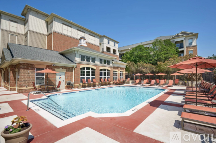 A large outdoor swimming pool surrounded by lounge chairs and umbrellas.