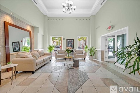 A spacious living room with a sofa set, a coffee table, and a chandelier.