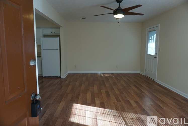 A room with wooden floors and a ceiling fan.