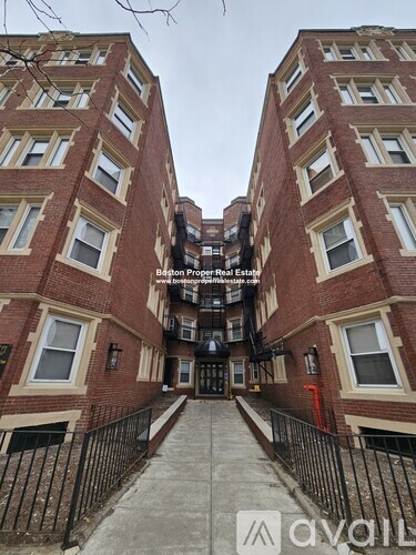 A red brick building with a black iron fence in front.