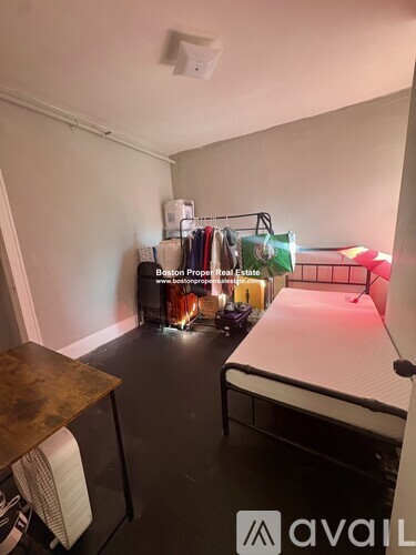 A room with a bed, desk, and a shelf with various items on it.