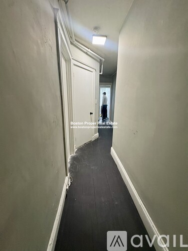 A long hallway with a person standing at the end.