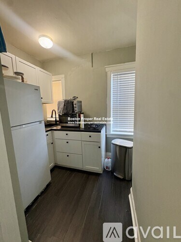 A kitchen with white appliances and cabinets.