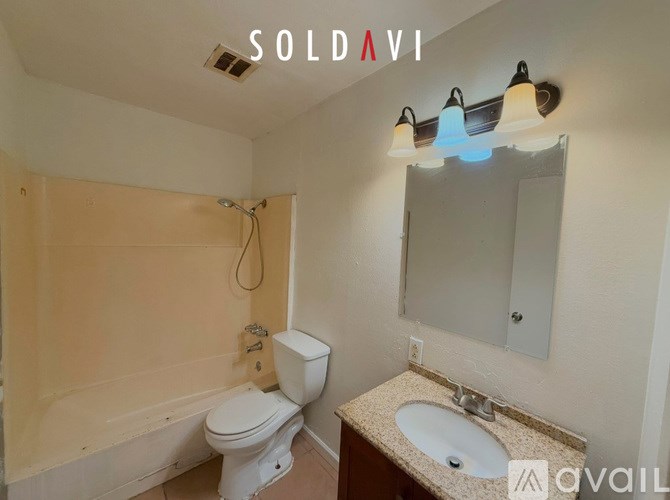 A bathroom with a toilet, sink, and mirror.