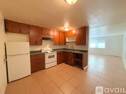 A kitchen with white appliances and brown cabinets.