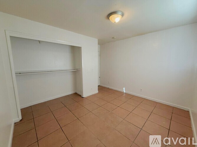 A room with a tiled floor and a single light fixture on the ceiling.